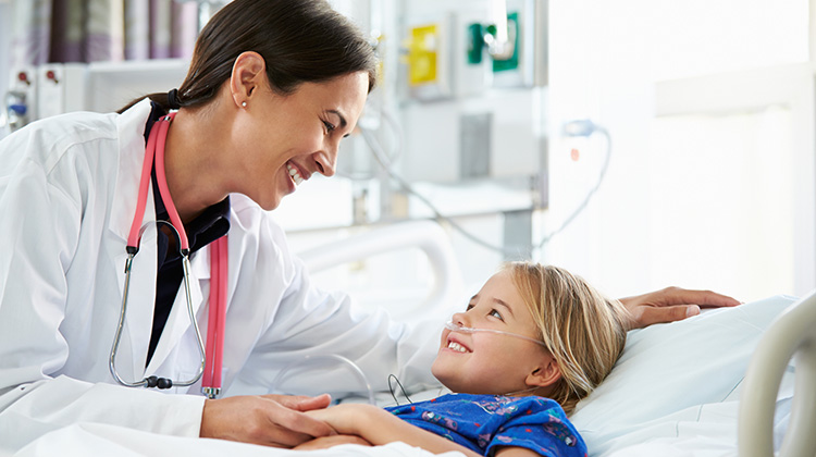 Imagen de la cabeza de un niño sostenida por las manos de un médico